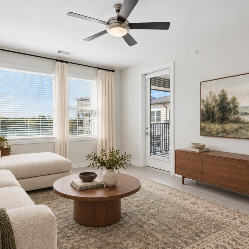 Bright living room at Aventon NorthRidge apartments with large windows, modern furnishings and ceiling fan