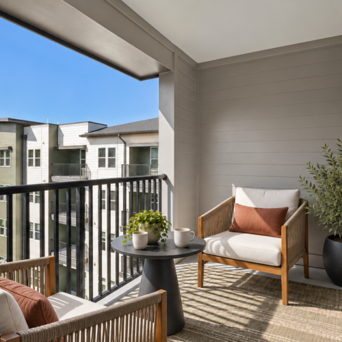 Private balcony at Aventon NorthRidge apartments with outdoor seating and community views